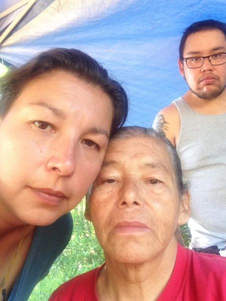 Pictou Landing band members Tonya Francis, Maurina Beadle and 'Jono' Beadle remain at a sacred fire adjacent to the ruptured effluent pipe. They and others claim to have found ancestral graves adjacent to the ruptured pipe and say that contractors are already disrupting ancient grave sites. [Photo: Don Brooks]