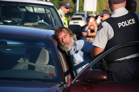 Greg Cook gets roughed up by RCMP. [Photo: Miles Howe]
