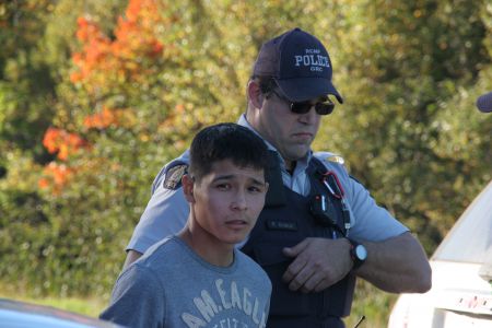 This young man was arrested for leaning on an RCMP cruiser. [Photo: Miles Howe]