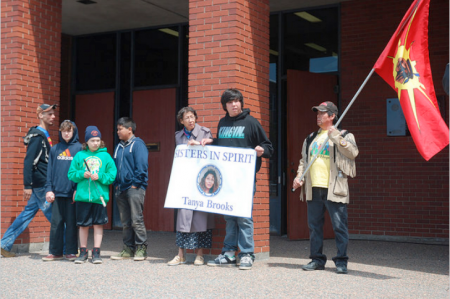 Tanya Brooks’ mother and five children stand by as speeches are made at the police station. [Photo: Rebecca Hussman]