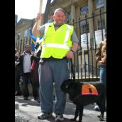 One protester smiling at his assistance dog in the sunshine