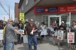 Sydney: Breton CUPW local president Gordon MacDonald, left, and CBDLC president Todd MacPherson, middle, lead a rally of postal workers and their supporters in front of the Canada Post office on Charlotte Street, Saturday. T.J. Colello - Cape Breton Post