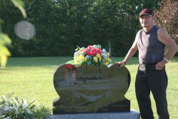 Paul Bourque stands beside his brother's tombstone. [Photo: M. Howe]