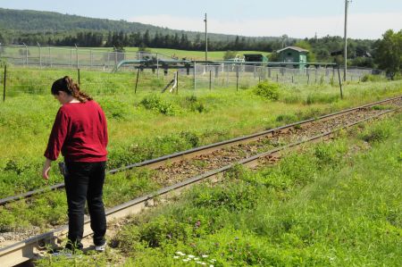 Penobsquis resident Heather McCabe inspects the railway tracks which run by a gas well.