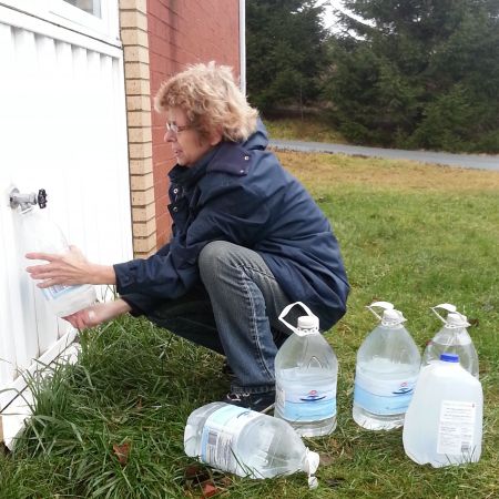 Marlene Brown fills water jugs at St. Paul's Church in Spryfield.