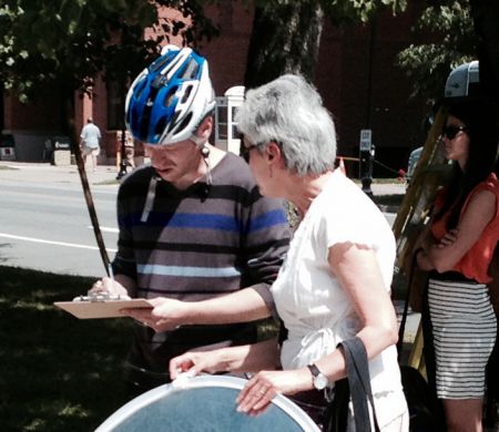 Violet offers a person on a bike the chance to sign a letter to the PM