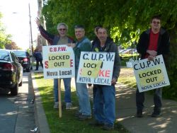 CUPW strikers wave to honking traffic at the community support rally on Thursday.