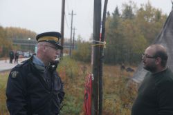 Jason Augustine, District War Chief of Signigtog, speaks to an RCMP officer on October 17th. [Photo: M. Howe]